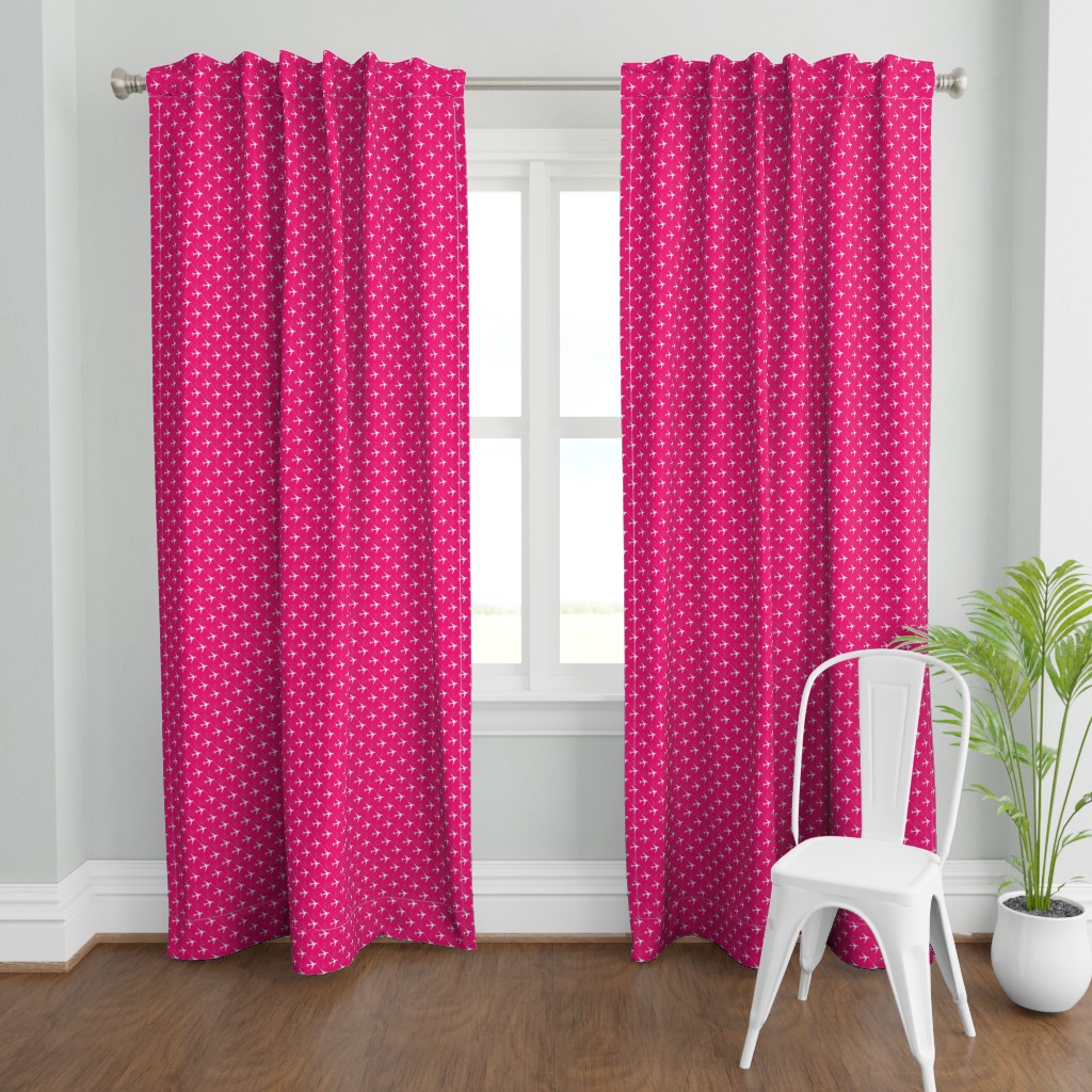 A wide shot with a two Curtain panels hanging from a curtain rod in front of an open window. A plant and a chair are in front and to the right of the right panel.