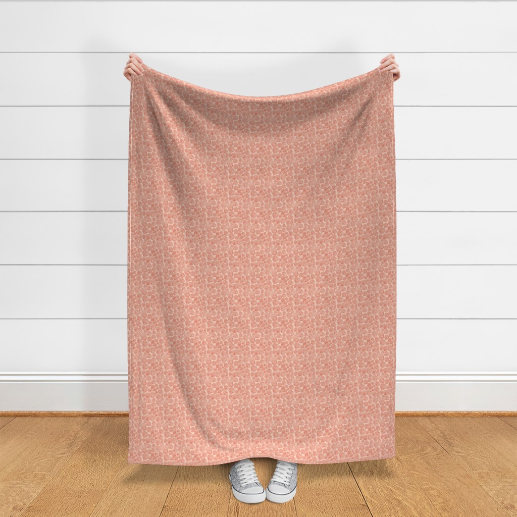 A person holding up a throw blanket in front of a shiplap wall