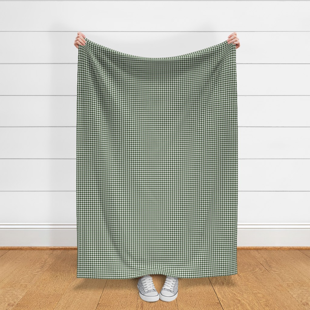 Throw blanket held up in front of a white shiplap wall
