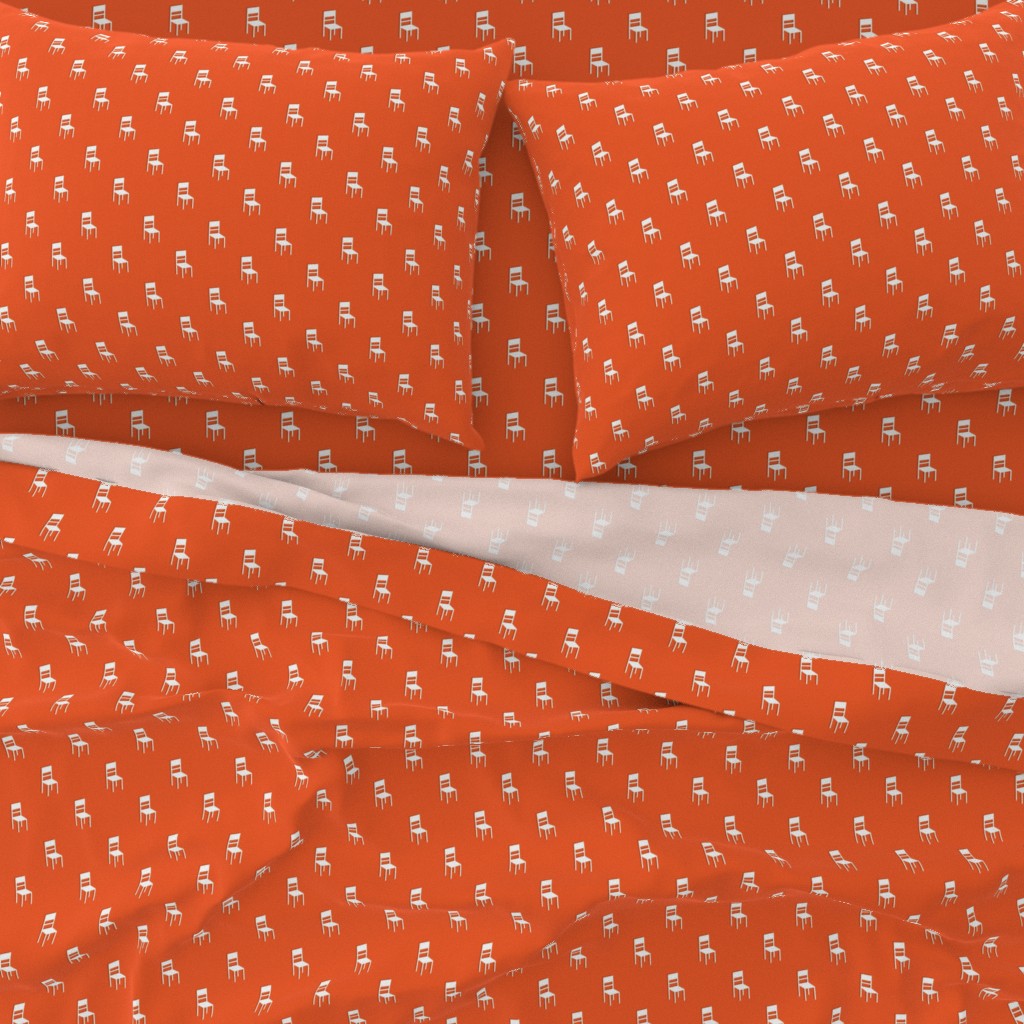 A close-up top down view of a bed with pillowcases and the top sheet pulled down slightly