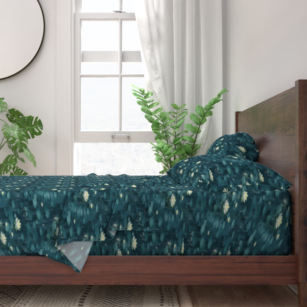 A neatly made bed with sheets and pillows with a wooden bedframe. The bed is next to a window with plants on either side and a round mirror hangs on the wall to the left of the window.