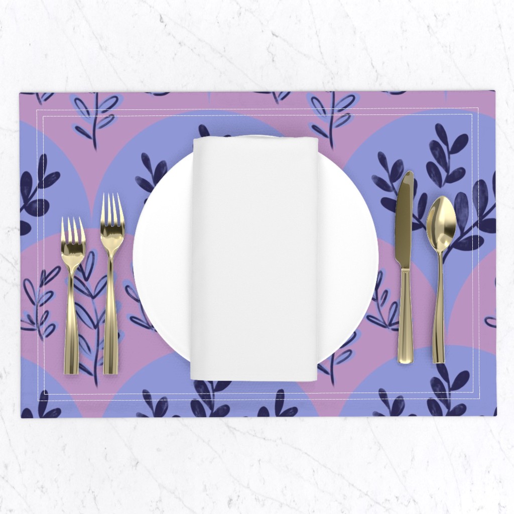 Top down of a table setting on a white marble table, a placemat with a plate and napkin and gold silverware set