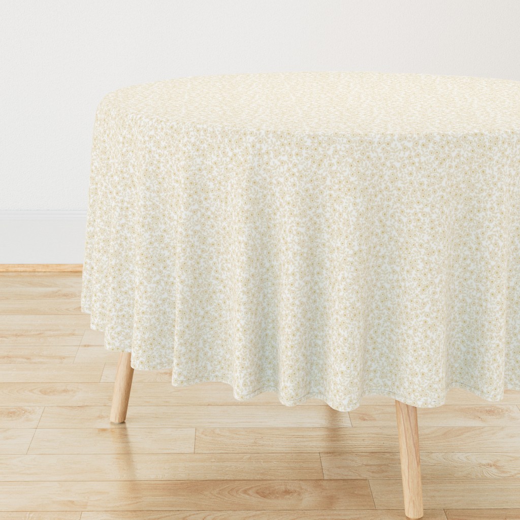 Side view of a circular wooden table with a Tablecloth draped over it, sitting on top of light wood floors
