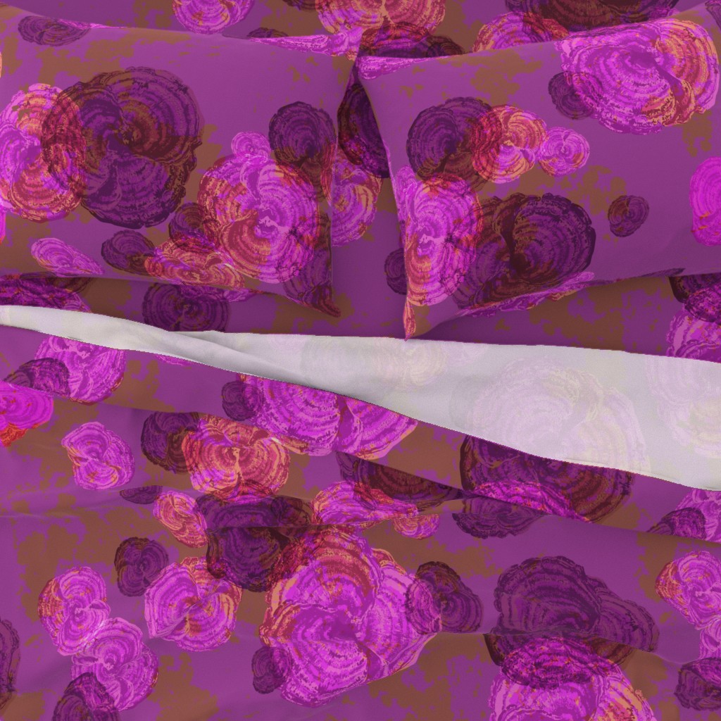 A close-up top down view of a bed with pillowcases and the top sheet pulled down slightly