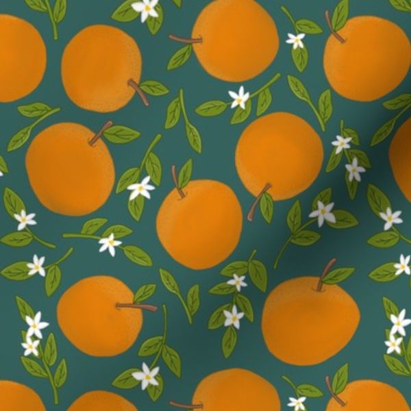 Oranges and blossom leaves on dark teal