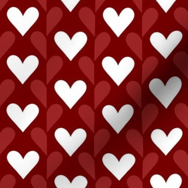 Bold red and white hearts in a half-drop pattern on crimson red background
