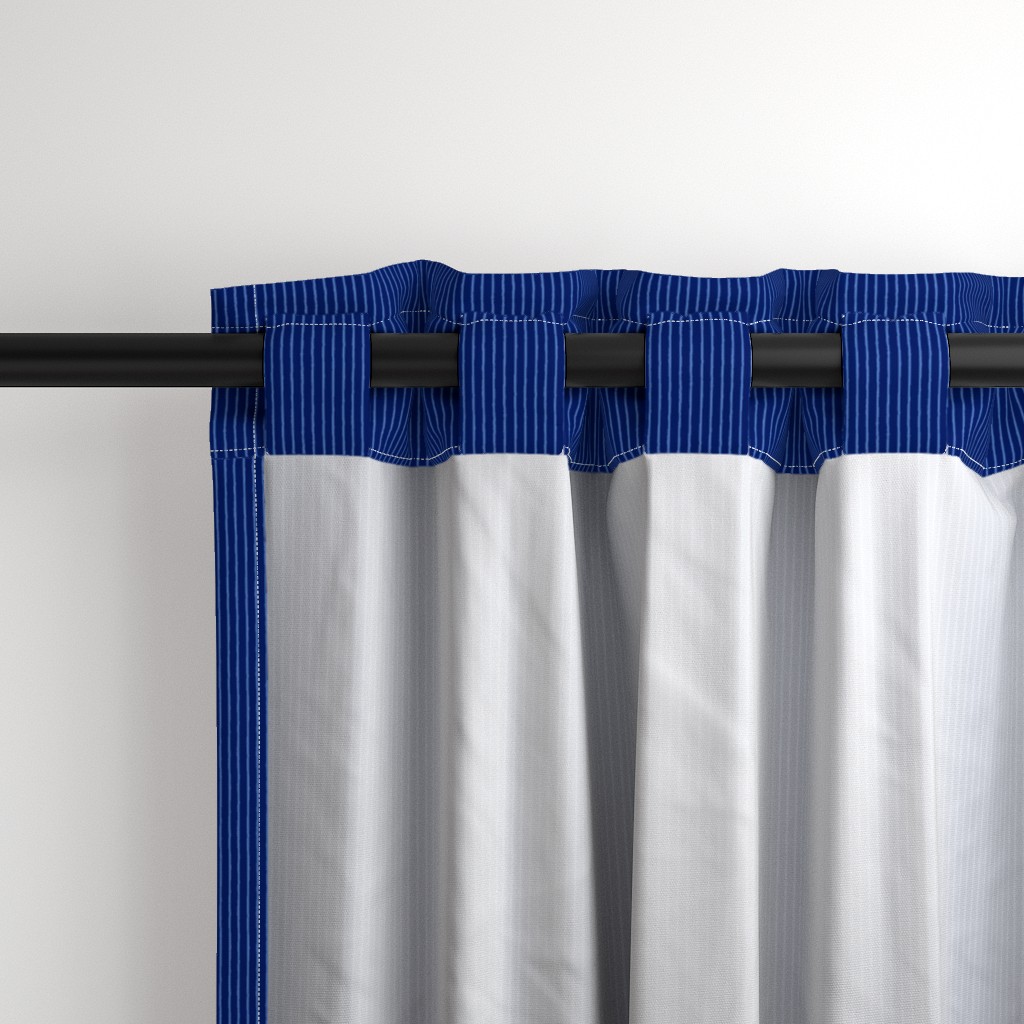 Close up of the back a Curtain panel hanging from a black curtain rod showing the tab hanging option