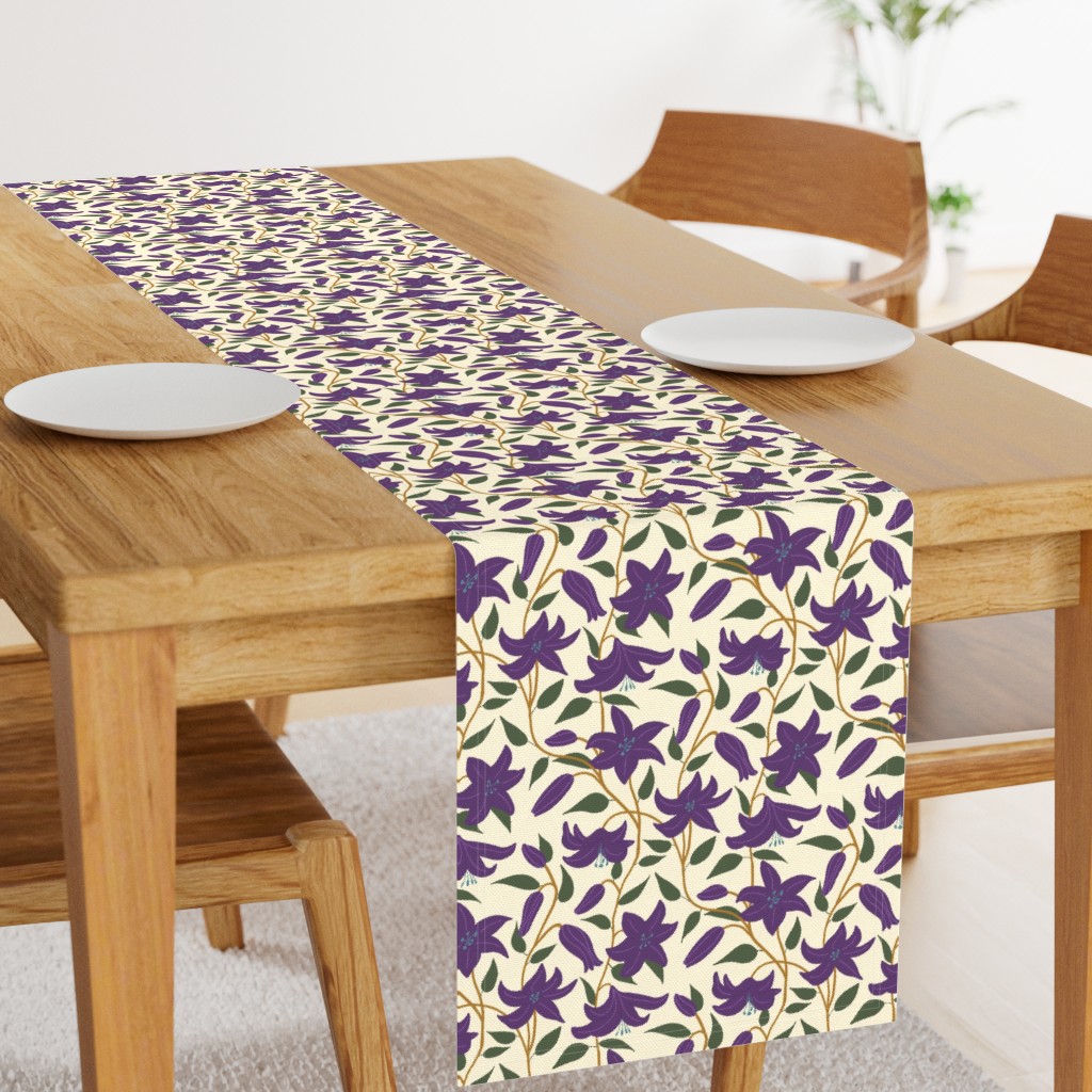 Angled light wood table with a 108 inch long Table Runner in the middle and two plates