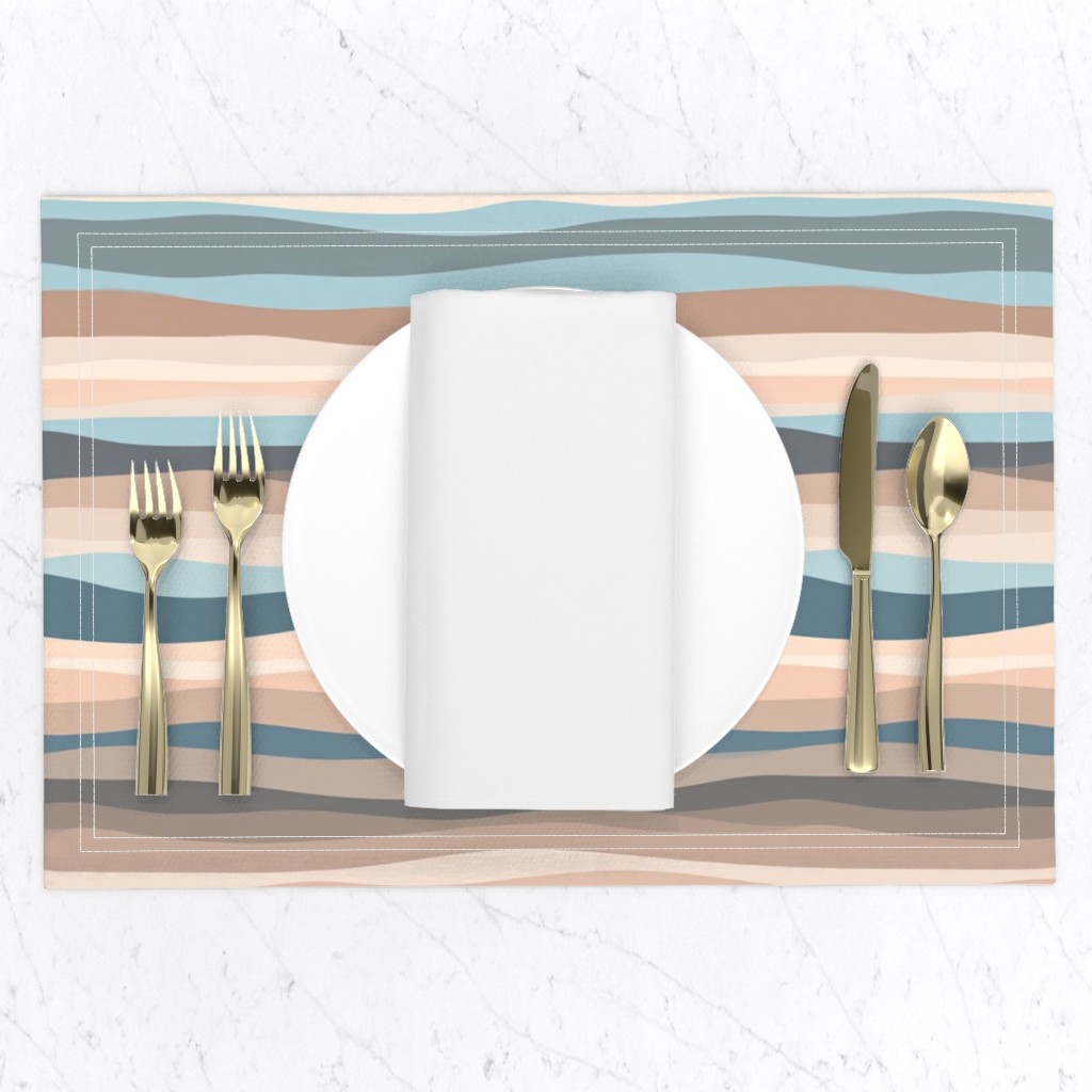 Top down of a table setting on a white marble table, a placemat with a plate and napkin and gold silverware set