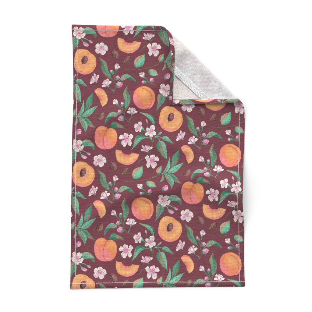 A Tea Towel laying out flat on a white background with the top right corner folded over showing the hem and unprinted backing with the white hanging tab