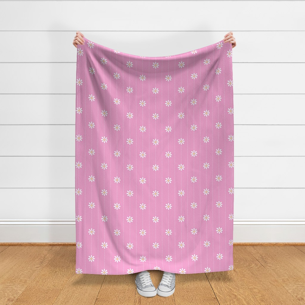 A person holding up a throw blanket in front of a shiplap wall