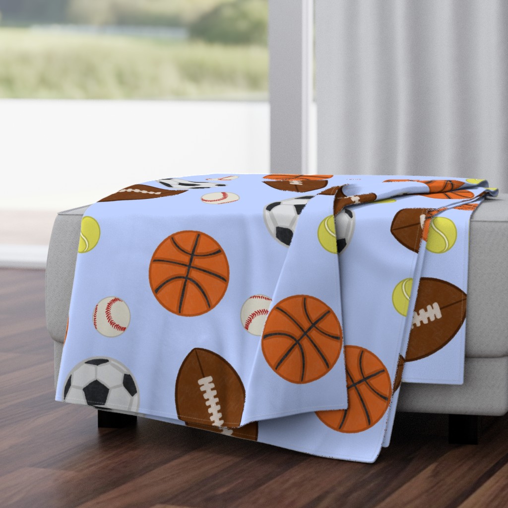 Folded Throw Blanket draped over a plush fabric ottoman in a living room in front of an open window with dark wood floors.