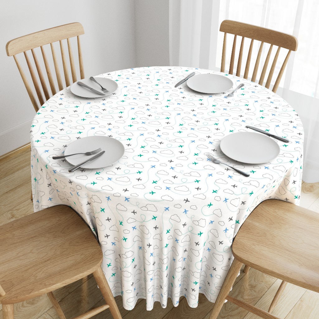 Top down angeled view of a wooden table with a 90 inch Round Tablecloth and four place settings arranged on top