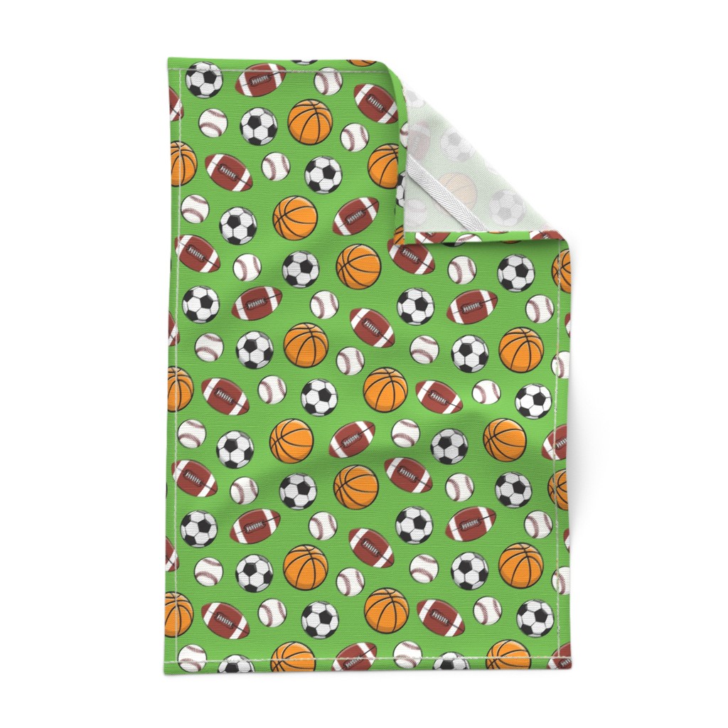 A Tea Towel laying out flat on a white background with the top right corner folded over showing the hem and unprinted backing with the white hanging tab