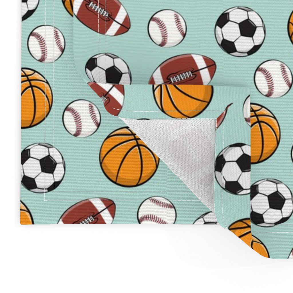 Close up of two Placemats stacked on top of eachother and the top left bottom corner is flipped up showing the hem and unprinted back