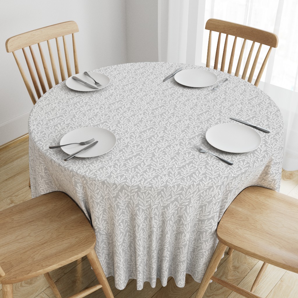 Top down angeled view of a wooden table with a 90 inch Round Tablecloth and four place settings arranged on top